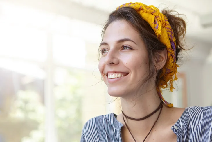 mujer sonriendo con fondo de una casa de día