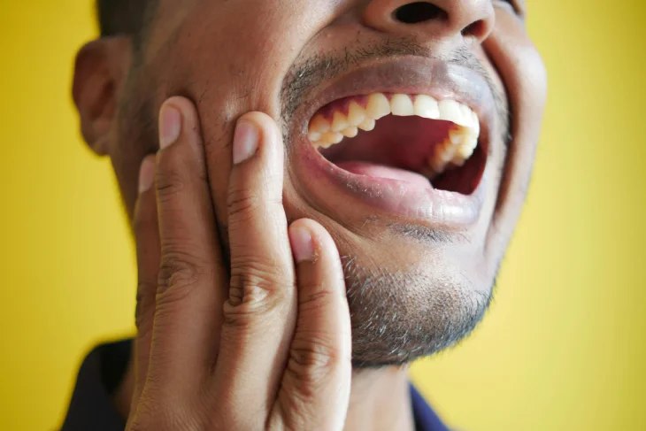 Hombre con dolor intenso en la boca debido a muelas rotas