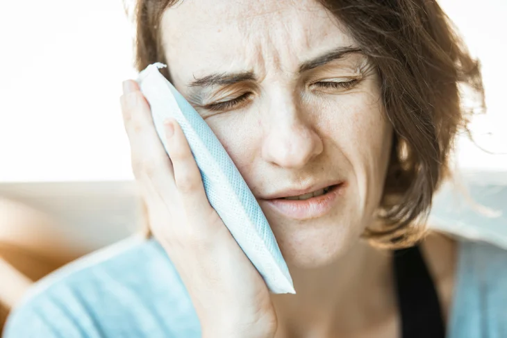 Mujer con dolor facial causado por una muela rota.