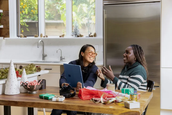 Dolor de encías: dos mujeres conversando y sonriendo en casa, imagen asociada a consejos y tratamiento dental para aliviar la inflamación de encías.
